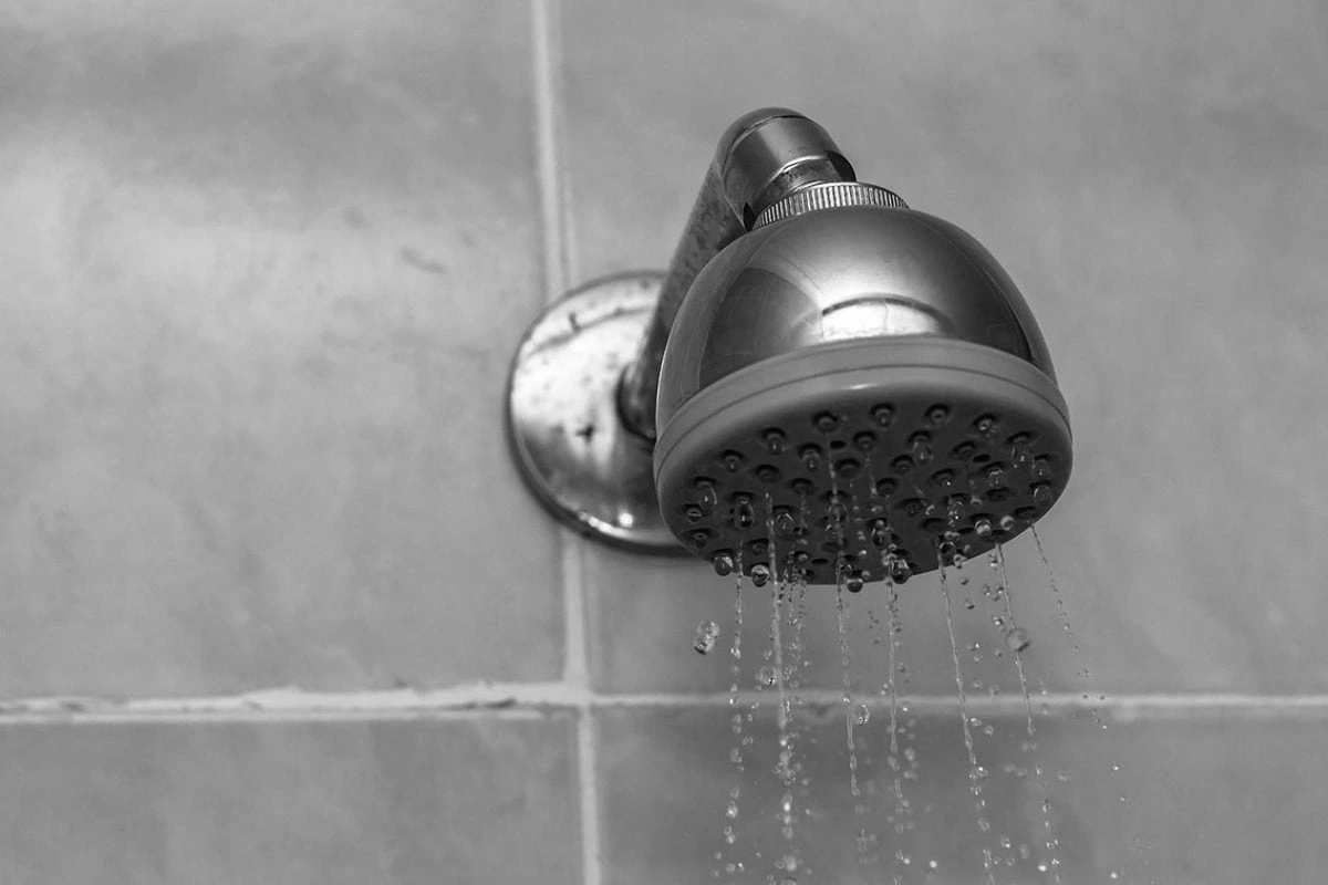 closeup grayscale shot showerhead water dripping down x ()