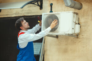 HVAC technician working on a capacitor part for condensing unit | Plumbing & Heating Paramedics