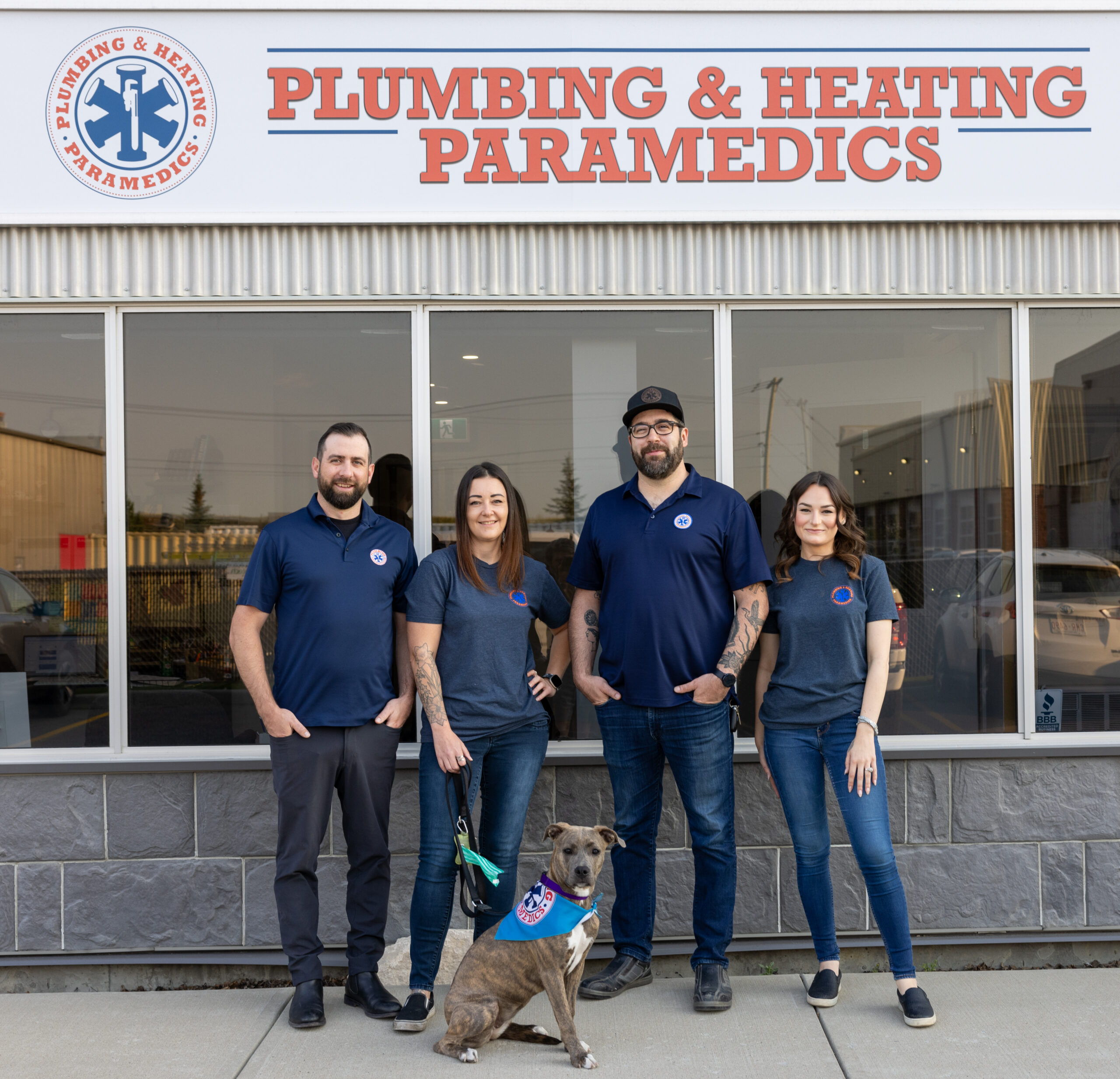 A group photo of employees dressed in company uniform stands in front of their company