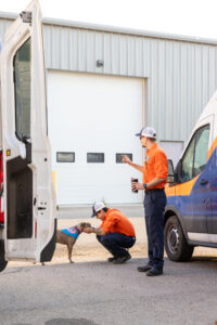 Two technicians are performing Air Conditioner Repair In Langdon, AB