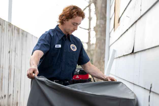 A technician performing Air Conditioner Maintenance in Calgary, AB