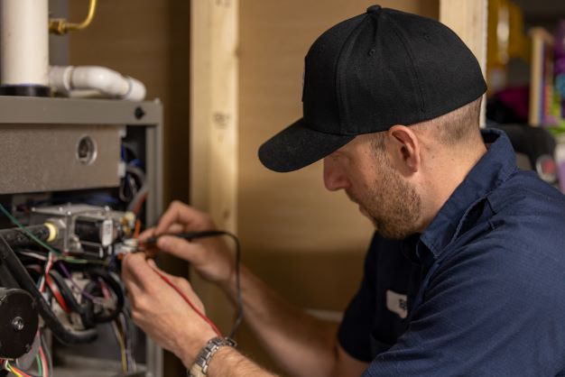 HVAC technician performing heating services on a residential heating system