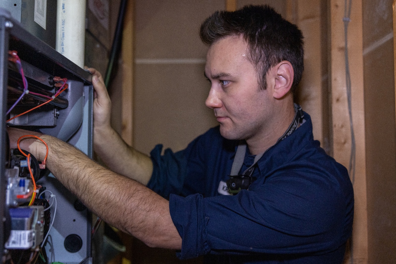 An HVAC technician is working on a furnace